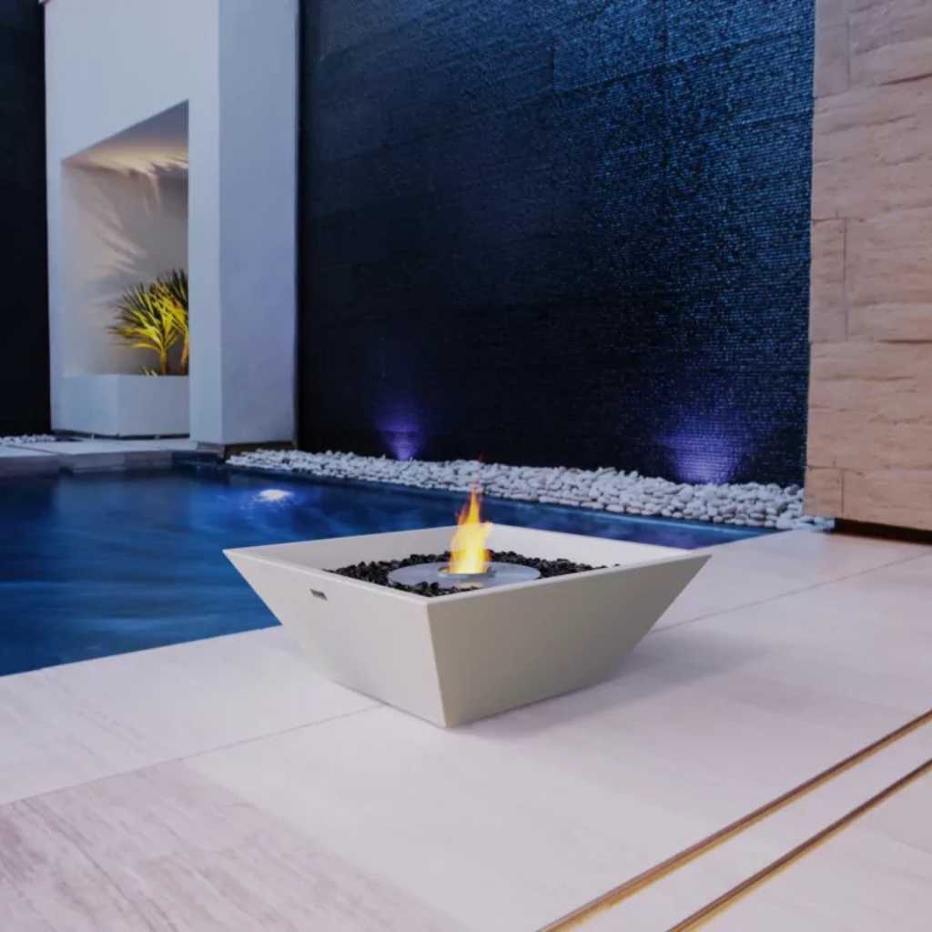 Outdoor fire feature in bone finish beside a modern swimming pool
