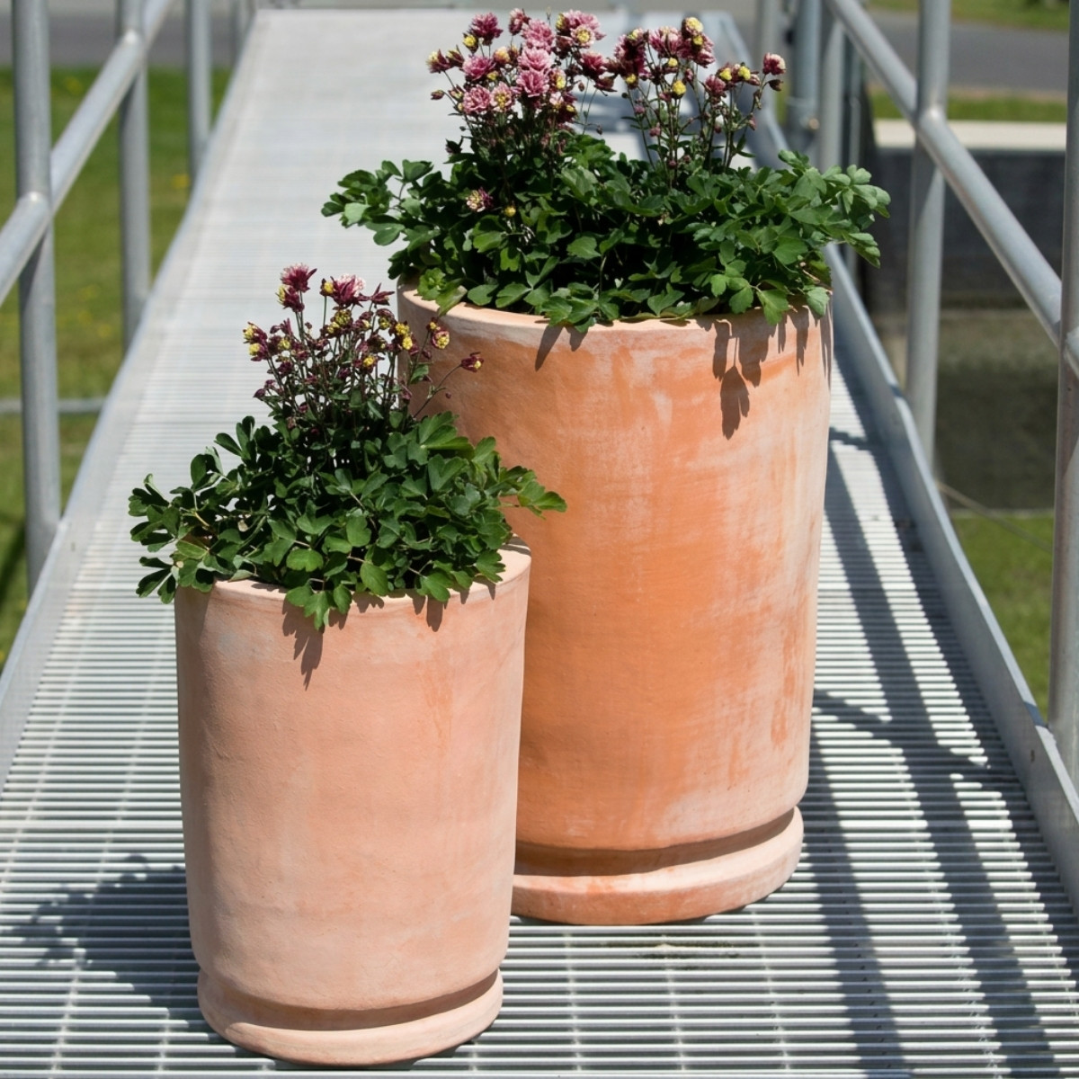 Posada planters in natural clay terracotta with two cylindrical modern forms and drainage holes