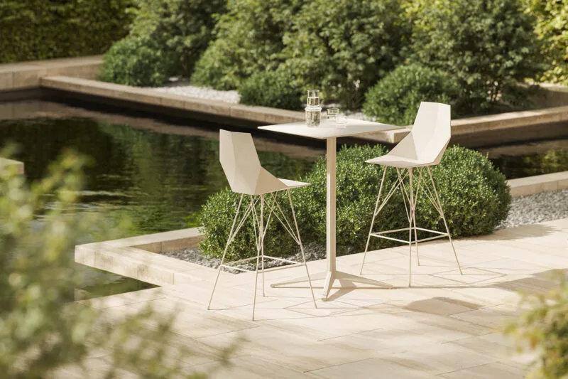 Vondom-Faz-Stool-hospitality-design Geometric outdoor bar stools and high table beside a landscaped pool terrace