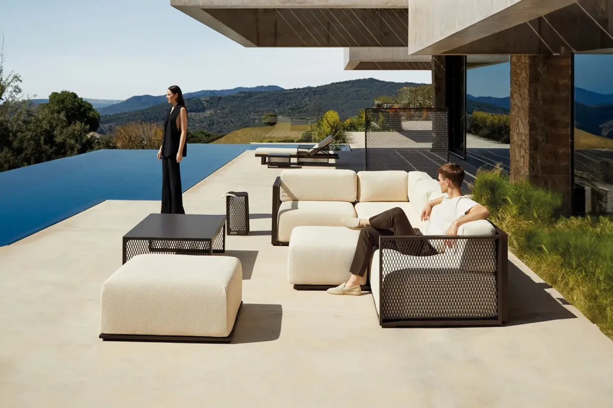 Vondom-The-Factory-Collection The factory collection modular outdoor sectional and pouf beside an infinity pool with mountain views